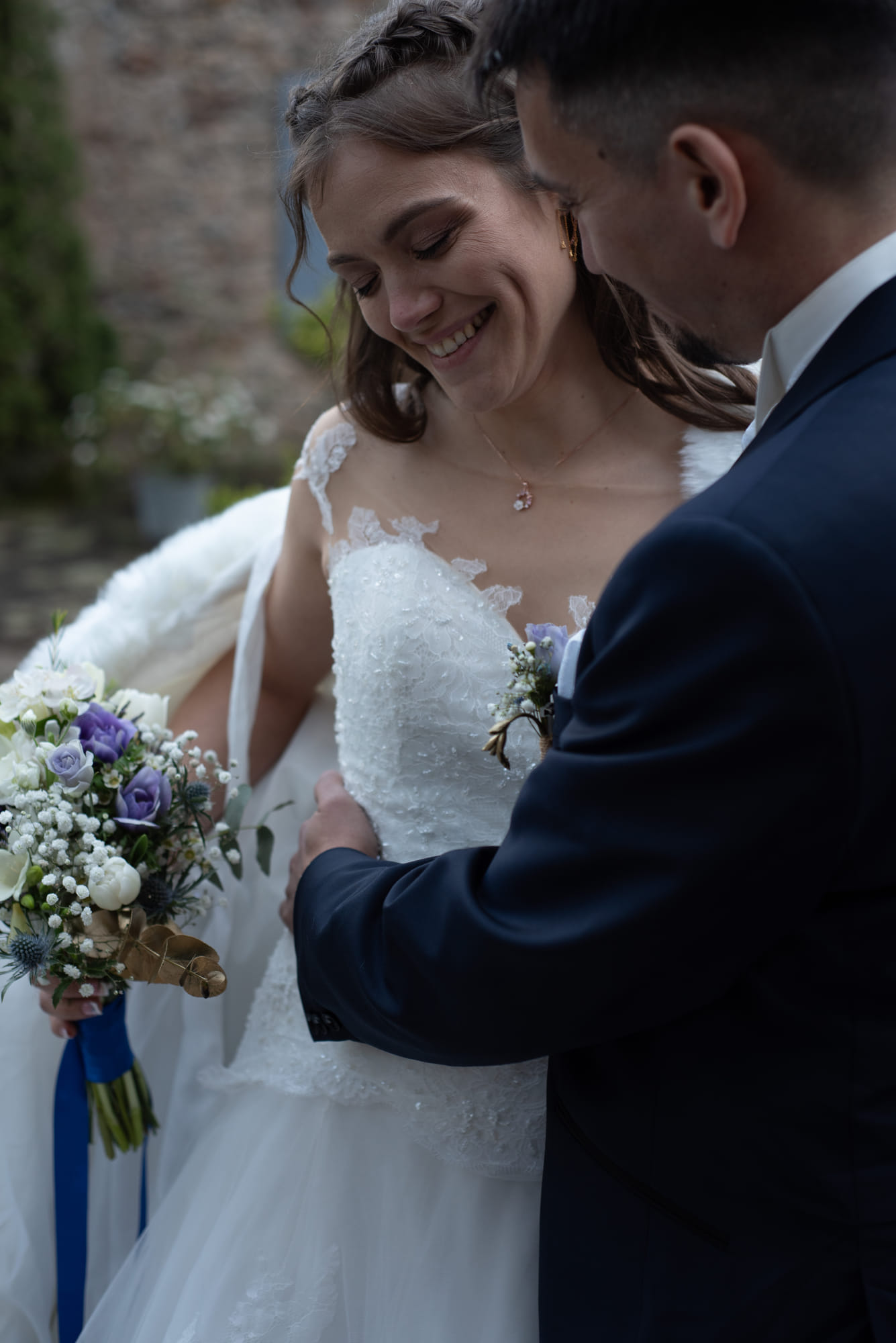 Mariée et marié proches, bouquet blanc et ruban bleu au premier plan
