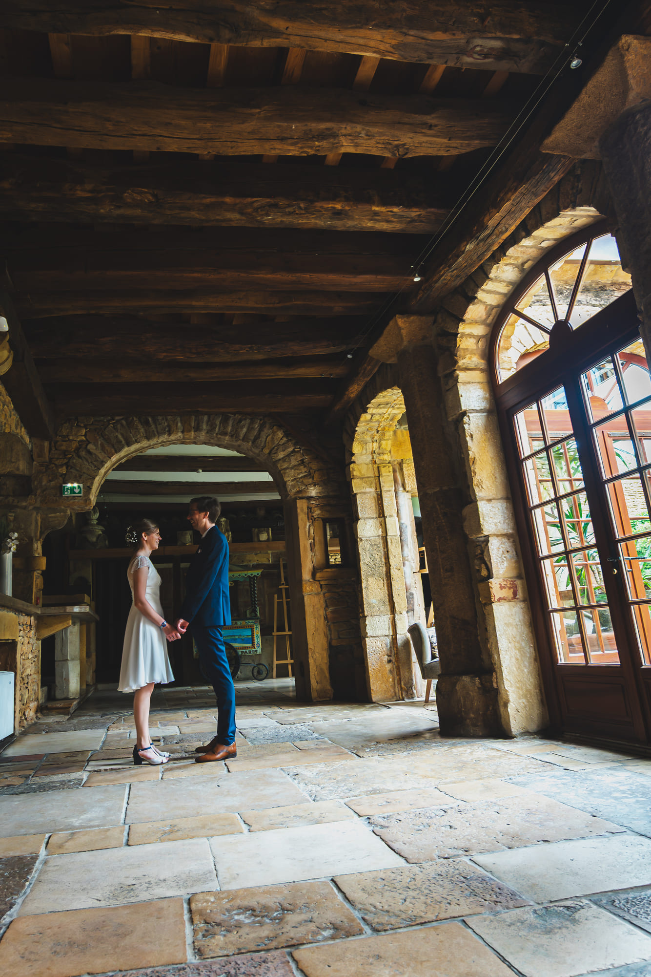 Laure et Mathieu se tenant la main dans une salle en pierre du Domaine de la Ruisselière
