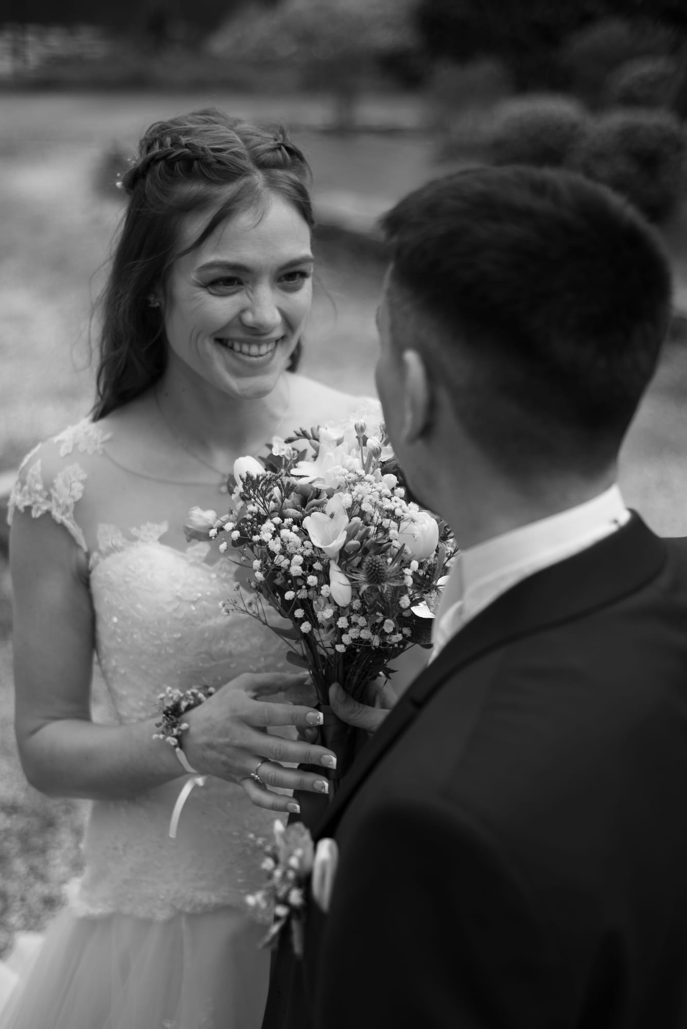 Portrait de mariée souriante, bouquet à la main, en noir et blanc