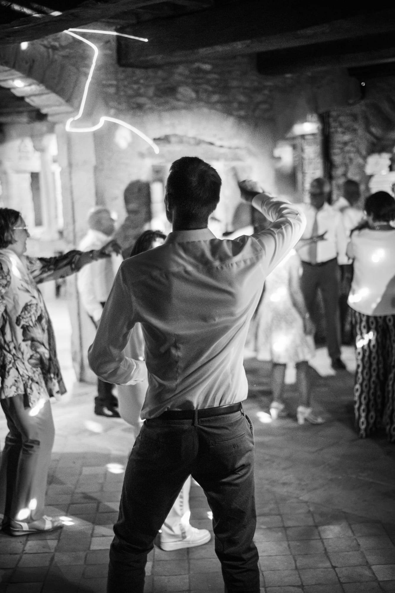 Invité les bras levés sur la piste de danse, dans une salle en pierre en noir et blanc