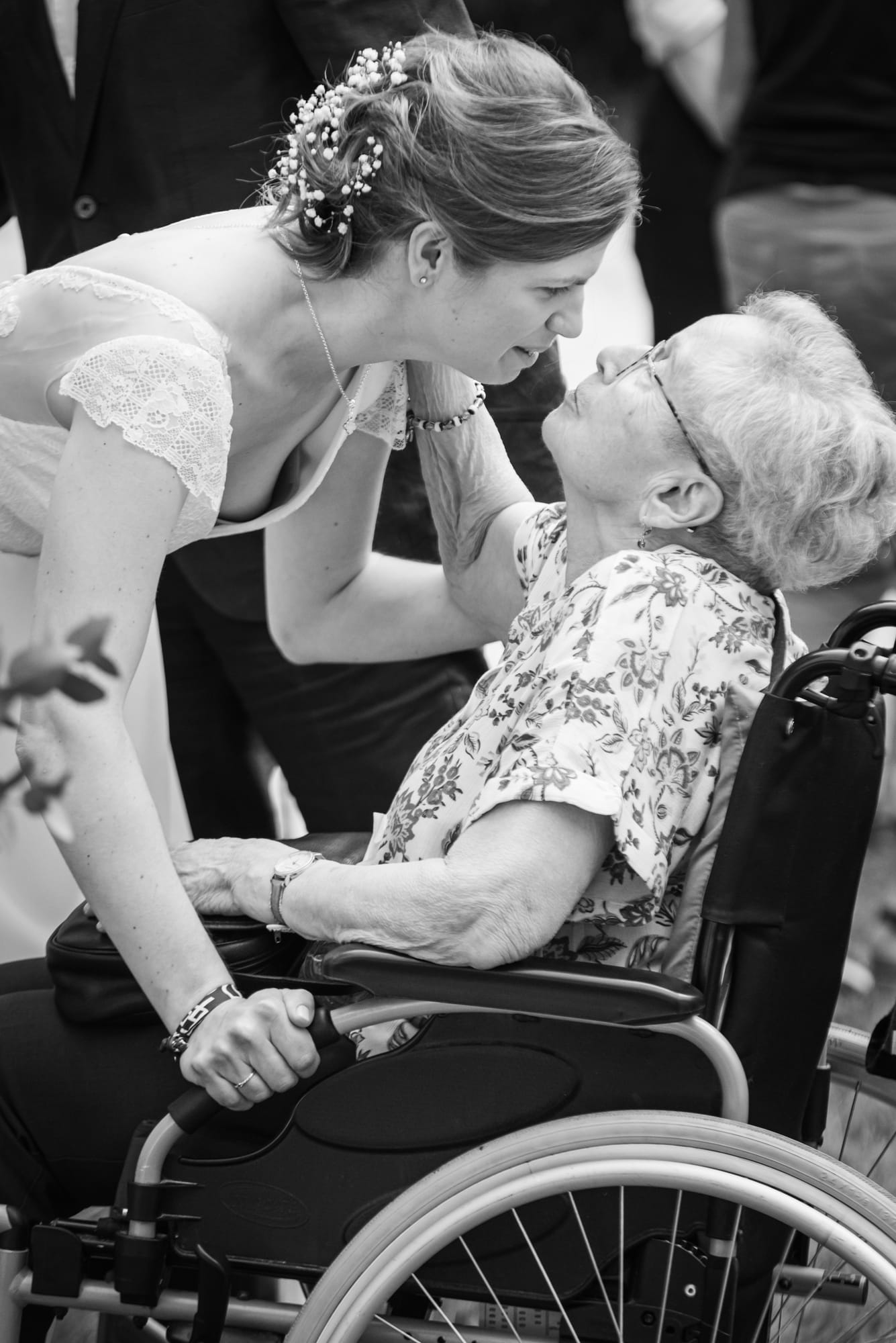 Laure penchée vers une aînée en fauteuil, au Domaine de la Ruisselière