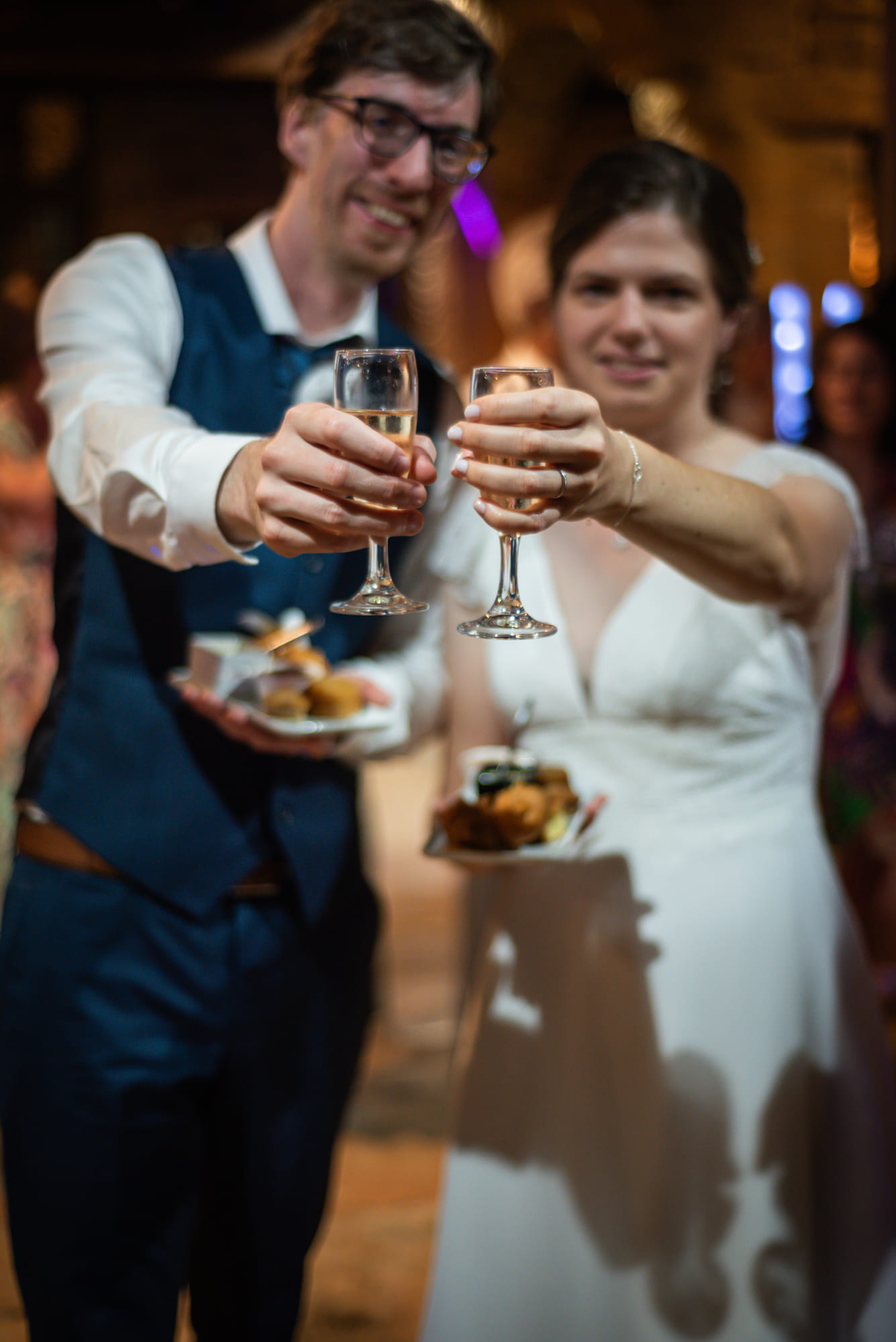 Laure et Mathieu trinquant, flûtes de champagne à la main, au Domaine de la Ruisselière